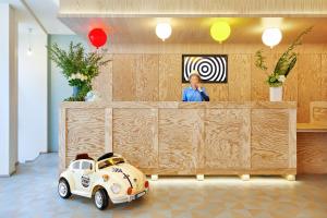 a man standing behind a counter with a toy car at Hotel Joke - Astotel in Paris