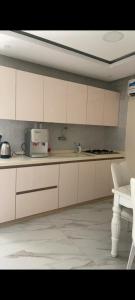 a kitchen with white cabinets and a sink and a microwave at شاليه تريك in Buraydah