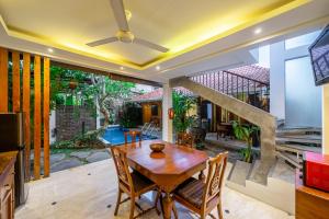 una sala da pranzo con tavolo e sedie in legno di Villa Arumanis a Canggu