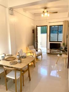 a living room with a table and chairs at Namal Apartelle - Free Scooter & Concierge Service in El Nido