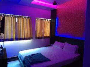 Un dormitorio con una cama con luces moradas. en Hotel Raj Residency, Patna, en Patna