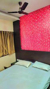 a bedroom with a bed with a red wall at Hotel Raj Residency, Patna in Patna