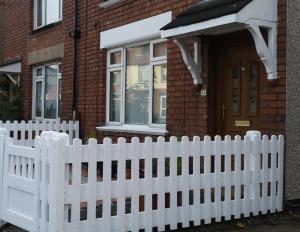 uma cerca branca em frente a uma casa em Stylish 1 bedroom Haven em Coventry