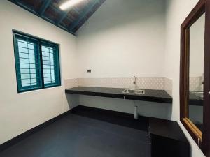 eine Küche mit einer Theke und einem Waschbecken in einem Zimmer in der Unterkunft Cliff & Coral in Varkala