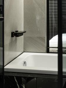 a bathroom with a bath tub with a window at Autumn Willow Hotel in Taichung