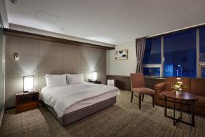 una camera d'albergo con letto, scrivania e sedia di Hotel Interciti a Daejeon