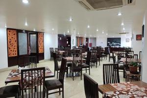 a dining room with tables and chairs in a restaurant at Jain Group- Keepsa Residency & Spa, Gangtok in Gangtok