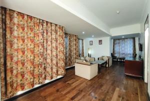 a living room with curtains and a desk and a couch at Jain Group- Keepsa Residency & Spa, Gangtok in Gangtok