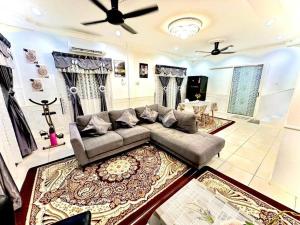 ein Wohnzimmer mit Couch und Fernseher in der Unterkunft Corner Lot Terrace House Taman Bahagia Batu 7 (2Min to Airport) in Sandakan
