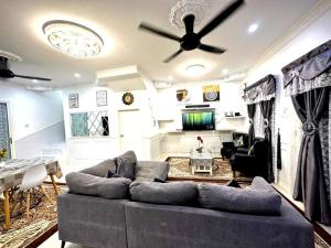ein Wohnzimmer mit einer Couch und einem Deckenventilator in der Unterkunft Corner Lot Terrace House Taman Bahagia Batu 7 (2Min to Airport) in Sandakan + 8 Fotos