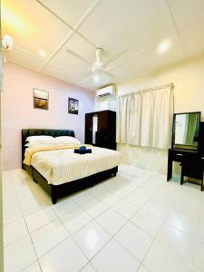 ein Schlafzimmer mit einem Bett und einem Fernseher darin in der Unterkunft Corner Lot Terrace House Taman Bahagia Batu 7 (2Min to Airport) in Sandakan