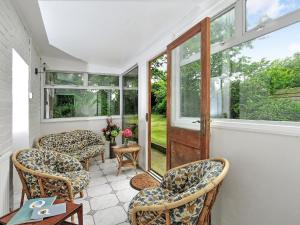 a screened in porch with chairs and a window at Manor Villa in Llanrian