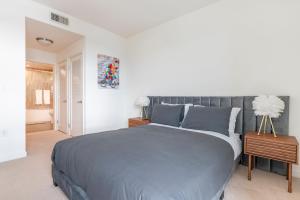 een slaapkamer met een groot bed met een grijze sprei bij Brand New Luxury Apartment WeHo in Burbank