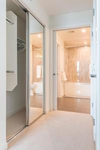 een glazen deur naar een badkamer met een bad bij Brand New Luxury Apartment WeHo in Burbank