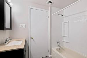 uma casa de banho branca com um lavatório e um chuveiro em Stunning 2br Near Everything - City Center em Filadélfia