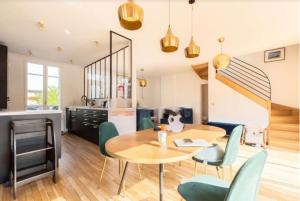 a kitchen and dining room with a table and chairs at Maison avec jardin 20min de Paris in Asnières-sur-Seine