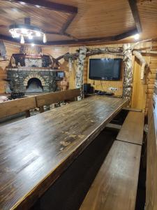 a large wooden table in a room with a fireplace at Садиба Тарниця in Krivorovnya