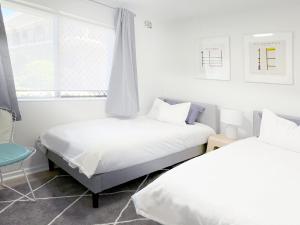 two beds in a white room with a window at Stylish 2Bdrm in Trendy Area -Close to City & Beach in Perth