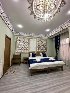 a bedroom with a bed and a chandelier at Hotel Zarhal in Bukhara