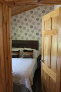 a bedroom with a bed and a open door at Beechtree Chalet in Warrenpoint