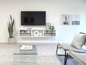 a living room with a tv on a white wall at Stylish 2Bdrm in Trendy Area -Close to City & Beach in Perth