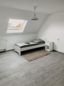 een witte kamer met een bed en een tapijt bij Wohnen im 3 Ländereck! Essen, Mülheim, Oberhausen. BSDG in Essen