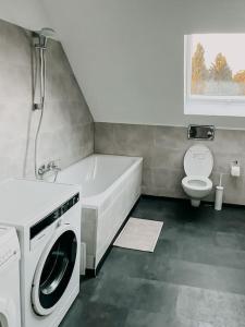 ein Badezimmer mit einer Badewanne und einer Waschmaschine in der Unterkunft Wohnen im 3 Ländereck! Essen, Mülheim, Oberhausen. BSDG in Essen