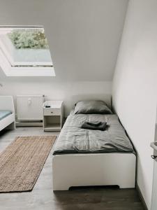 a white bedroom with a bed and a window at Wohnen im 3 Ländereck! Essen, Mülheim, Oberhausen. BSDG in Essen