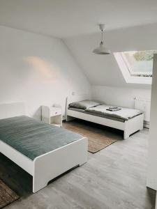 two beds in a room with white walls at Wohnen im 3 Ländereck! Essen, Mülheim, Oberhausen. BSDG in Essen