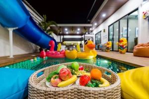 een zwembad met een fruitschaal in het midden van een zwembad bij White Cloud Luxury Pool Villa Cha Am in Cha Am