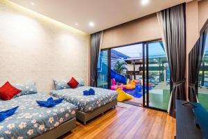 sypialnia z 2 łóżkami i kącikiem zabaw w obiekcie White Cloud Luxury Pool Villa Cha Am w mieście Cha Am
