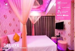 a bedroom with a bed with pink curtains and a tv at Cupid Hotel 2 in Ho Chi Minh City