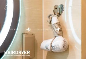 a hair dryer hanging on a wall next to a phone at Cupid Hotel 2 in Ho Chi Minh City +9 photos