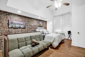 - une chambre avec un canapé et un mur en briques dans l'établissement Uniquely Designed Metropolitan Apt In Center City, à Philadelphie