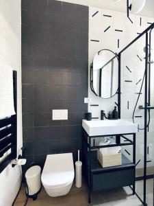 une salle de bain avec toilettes, lavabo et miroir dans l'établissement Cosy & central apartment, à Timişoara