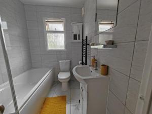 uma casa de banho branca com uma banheira, um WC e um lavatório. em Stylish 1 bedroom Haven em Coventry