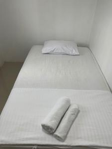 ein Bett mit zwei Handtüchern darüber in der Unterkunft Palace Hostel พาเลส โฮสเทล in Amphoe Phra Khanong