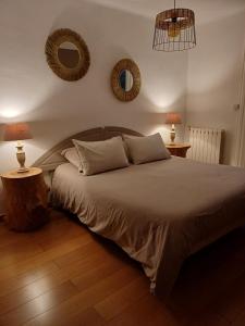 um quarto com uma cama com 2 candeeiros e 2 espelhos em La Grange em Cazouls-d Herault