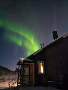a house with the aurora in the sky at Elvestua house in nature in Gibostad