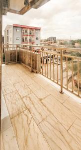 - un balcon avec balustrade en bois dans un bâtiment dans l'établissement Boston Residences Bonamoussadi, à Douala