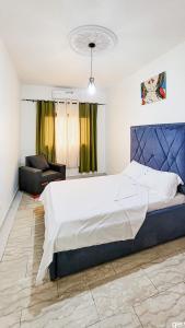 - une chambre avec un grand lit et un canapé dans l'établissement Boston Residences Bonamoussadi, à Douala