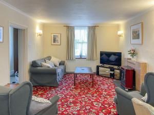 a living room with a couch and a tv at Manor Villa in Llanrian
