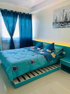 a bedroom with a blue bed with blue curtains at The Persimmon Studios Tower 3 Unit 1153 located in MJ Cuenco Cebu City in Cebu City