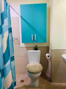 a bathroom with a toilet with a blue cabinet at The Persimmon Studios Tower 3 Unit 1153 located in MJ Cuenco Cebu City in Cebu City