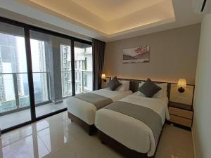 two beds in a hotel room with large windows at Genting Peak 2BR6Pax421 @Ion Delemen in Genting Highlands
