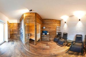 ein Zimmer mit einer Holzwand mit Stühlen in der Unterkunft Apartment in Bramberg am Wildkogel with barbecue in Bramberg am Wildkogel