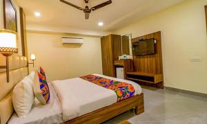 um quarto com uma cama e uma televisão em FabHotel Regency K9 Model Town em Jalandhar