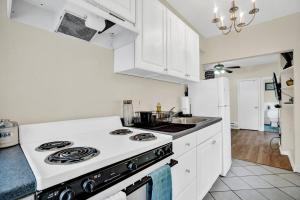 uma cozinha com armários brancos e um forno com placa de fogão em Location, Location, Nice Vibrant Center City Flat em Filadélfia