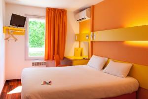 een hotelkamer met een wit bed en een raam bij The Originals Access, Hôtel Bordeaux Lac in Bruges