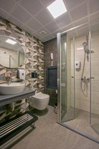 a bathroom with a toilet and a sink and a shower at Monart City Hotel - All Inclusive Plus in Alanya